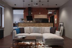 a living room filled with furniture next to a kitchen