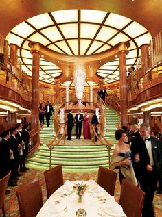 a large dining room with many people on the stairs