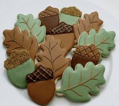 cookies decorated with leaves and acorns on a plate