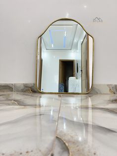 a bathroom mirror sitting on top of a marble counter