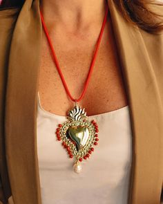 Rope necklace with brass sacred heart pendant surrounded by small red stones and pearls. Small baroque drop pearl on the finial.  Rope length: 60 cm  Sacred heart : 65 mm x 45 mm  Lobster clasp closure. A very versatile necklace that can also be worn every day, in the office, for a walk with friends or for a late afternoon drink. The sacred heart has a strong religious significance: it is the iconic symbol of Christianity, representing divine love and the suffering endured by Jesus Christ to sav Walk With Friends, The Sacred Heart, Red Stones, Divine Love, Red Rope, Christian Symbols, Jesus Christus, Late Afternoon, Rope Necklace