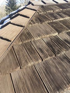 the roof of a house is made out of wood planks and has snow on it