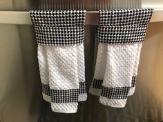 two black and white towels hanging on a towel rack