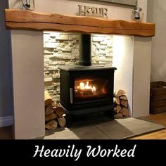 a living room with a fire place in the center and wood burning on the fireplace