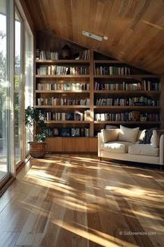 a living room filled with lots of furniture and bookshelves next to a sliding glass door