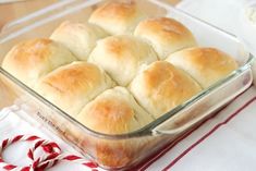 a casserole dish filled with rolls on top of a red and white table cloth