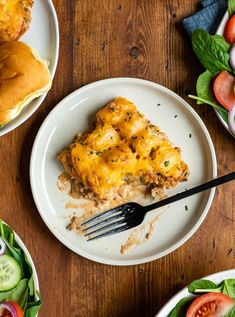 a white plate topped with lasagna covered in cheese next to other plates of food