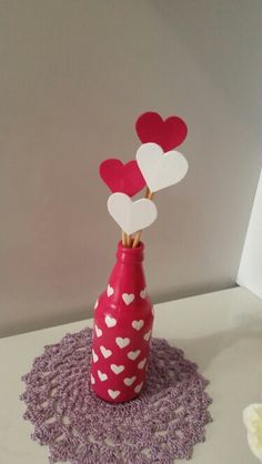 a red vase with hearts sticking out of it