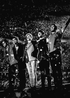 a group of people standing on top of a stage with their arms in the air