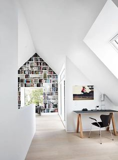 a room with a desk, bookshelf and window on the wall next to it