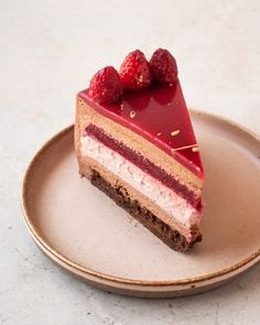 a piece of cheesecake with raspberries on top is sitting on a plate