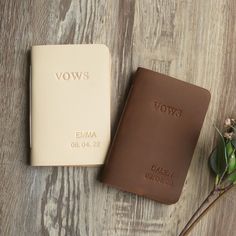 a brown leather book sitting next to a flower on top of a wooden table with the word vow's written on it