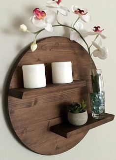 a wooden shelf with candles and flowers on it