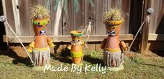 three native american style planters in front of a wooden fence with grass on them