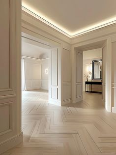 an empty room with white walls and parquet flooring in the center is lit by recessed lighting