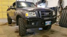 a truck parked in a garage next to another vehicle