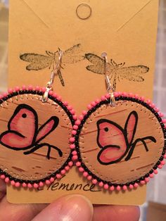 a pair of pink and black bird earrings