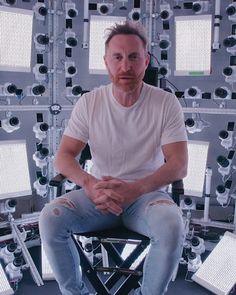 a man sitting on top of a chair surrounded by lots of lights