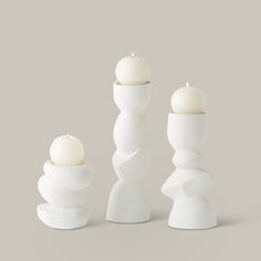 three white candles sitting next to each other