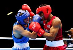 two men wearing red and blue boxing gloves, one is punching the other's head