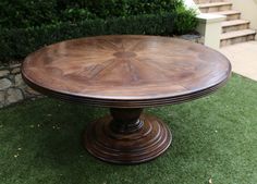 a wooden table sitting on top of a lush green field