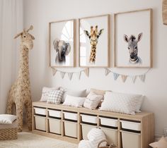 there are three pictures hanging on the wall in this child's room, and one has a giraffe