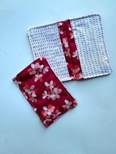 two red and white flowered napkins sitting next to each other