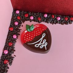 a heart shaped cake with chocolate and strawberries on it