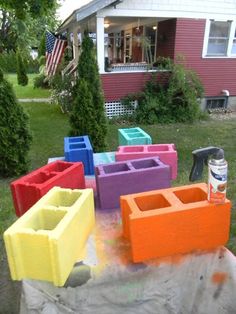 several different colored blocks sitting on top of a tarp in front of a house