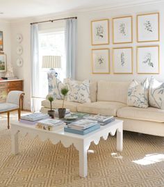 a living room filled with furniture and pictures on the wall above it's coffee table