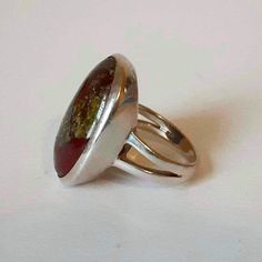 Classic bezel set design and Forest core colours seen here in this 1990s Minimalist Handmade 925 Sterling Silver and Dragons Bloodstone Statement Ring !  Increíble workmanship on this ring it Features a single Oval Cabochon Bloodstone Jasper measuring 23 x 15 mm  in and heavy beveled tapered bezel denting with  split shank on shoulders . Ring weighs 11 grams and is a size  7 3/4.  It is in great vintage condition with a beautiful patina on silver. Bloodstone Ring, Forest Core, Wedding Gift Baskets, Birthday Ring, Silver Dragon, Split Shank, Oval Cabochon, Set Design, Bezel Setting