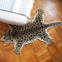 a leopard print rug on the floor next to a toilet