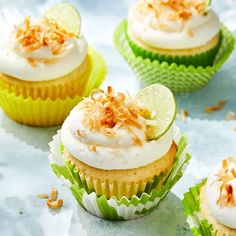 cupcakes with frosting, lime and coconut on the top are lined up