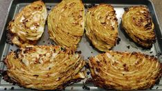 several pieces of cooked artichoke on a baking sheet