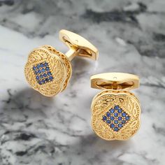 Gold Square Cufflinks with Blue Stones These gold square cufflinks with small blue stones combine elegance and subtle sophistication. The rich gold is beautifully offset by the delicate blue stones, making these cufflinks a versatile and refined addition to any formal or semi-formal ensemble. Dress Shirts: White Dress Shirt: A white dress shirt provides a classic and clean backdrop, allowing the gold and blue cufflinks to stand out. Light Blue Dress Shirt: The soft blue of the shirt complements Elegant Blue Cufflinks For Business, Classic Blue Jewelry For Business, Luxury Blue Cuff Jewelry, Elegant Gold Cufflinks, Classic Blue Cufflinks For Formal Occasions, Elegant Blue Cufflinks For Formal Occasions, Elegant Blue Cufflinks For Gift, Classic Blue Cufflinks With Polished Finish, Elegant Rectangular Cufflinks For Formal Occasions