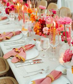 the table is set with pink and orange flowers