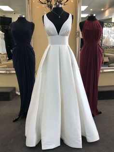 two dresses on mannequins in front of a dress shop display with black and white gowns