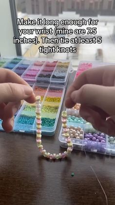 two hands reaching for beads on a table