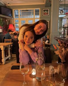 two women hugging each other at a table