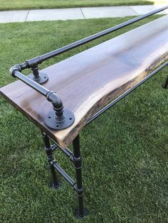 a wooden bench sitting on top of a lush green field