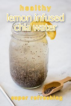 a glass jar filled with chia seeds next to a spoon and lemon wedges