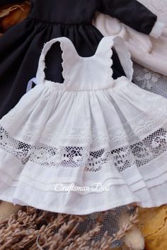 a white and black dress sitting on top of a pile of clothing