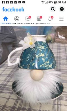 a fake face is placed on top of a coffee cup with a flower in it