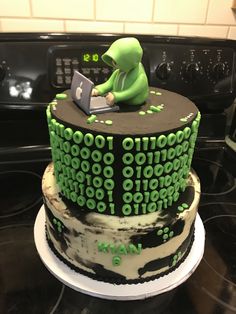 there is a cake that looks like an alien using a laptop on top of it