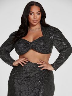 a woman in a black sequin skirt and crop top with her hands on her hips