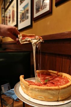 a deep dish pizza being served at a restaurant