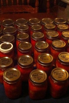 many jars filled with red liquid sitting on top of a table