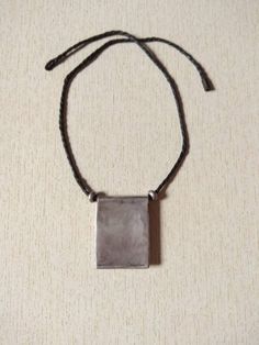 This is a moroccan saharian silver pendant with beautiful engraved decoration and with a thread of leather and two small silver berber beads. This pendant has a good size and weight to be worn. Length of leather thread : 50 cm (19,6 inches) Measures of the pendant : Length : 4,8 cm (1,9 inches) Width : 3,8 cm (1,5 inches) Measures of the silver beads : 0,4 cm x 0,9 cm (0,1 inches to 0,3 inches) Total Weight : 27 g Traditional Silver Rectangular Necklace, Silver Rectangular Jewelry For Blessing, Old Silver Coins, Moroccan Jewelry, Leather Thread, Coin Pendant, Silver Coins, Photo Jewelry, Cross Pendant