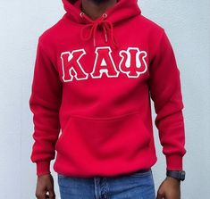 Elevate your casual wear game with this Kappa Alpha Psi Red Hoodie. The iconic brand of Kappa, known for its premium quality and design, makes this hoodie a must-have for men who appreciate style and comfort. The vibrant red color adds a pop of color to any outfit and is perfect for any occasion.  Crafted from high-quality materials, this hoodie is perfect for a brisk jog or a day out with friends. The Kappa Alpha Psi logo is prominently displayed, showcasing your affiliation with this renowned Cotton Hoodie With Double-lined Hood For Fan Gear, Red Cotton Hip Hop Hoodie, University Red Sweatshirt For Sports Season Streetwear, University Red Sweatshirt For Streetwear, University Red Sweatshirt For Sports Season, Red Fan Apparel Hoodie Sweatshirt, Casual Hoodie With Adjustable Hood For Fan Gear, College Red Hoodie With Letter Print, Red Hoodie With Letter Print For College