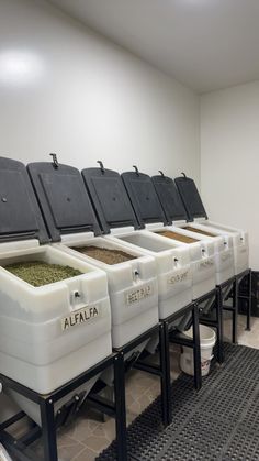 a row of white coolers sitting next to each other on top of a floor